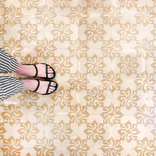 Travel inspiration—concrete tiles in soft beige and brown in Havana, Cuba, captured with striped pants and black sandals by Sarah Scales.