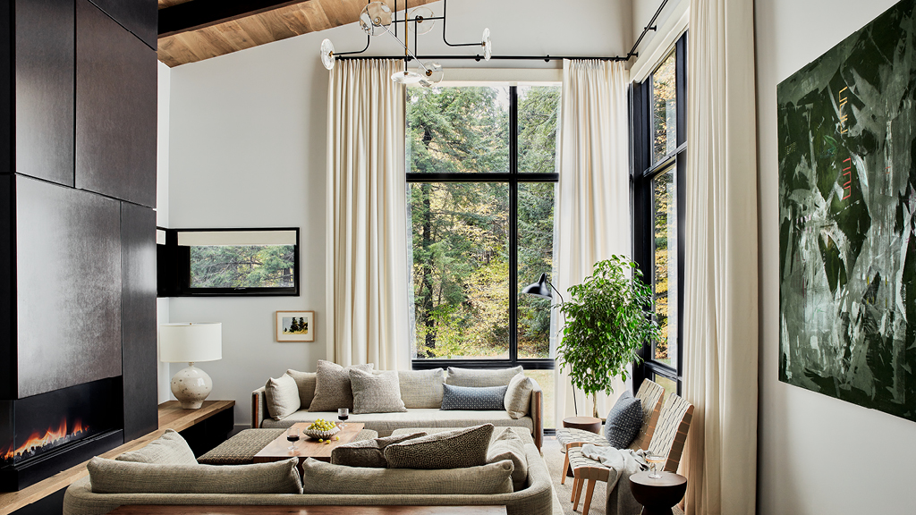 Designed by a Boston interior designer, this Stowe, Vermont living room features modern furniture, tall ceilings, and wood accents.