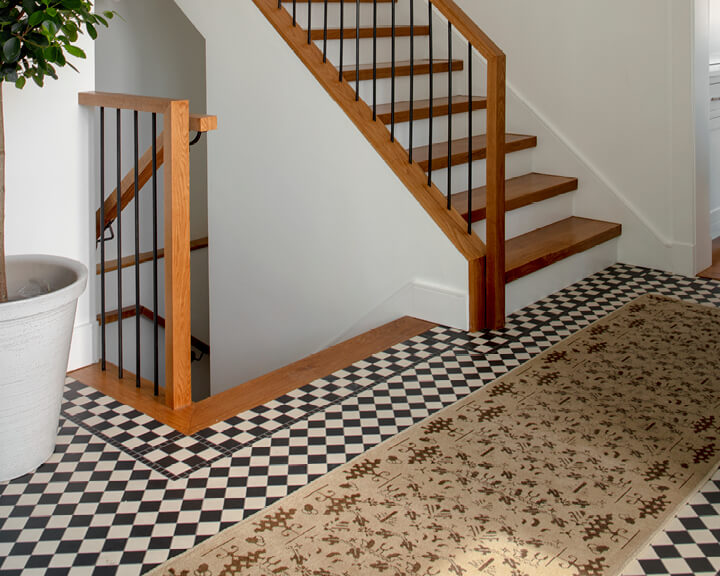 A vintage runner in a new construction home, featuring a modern stair design and a black-and-white checkered floor for contrast.