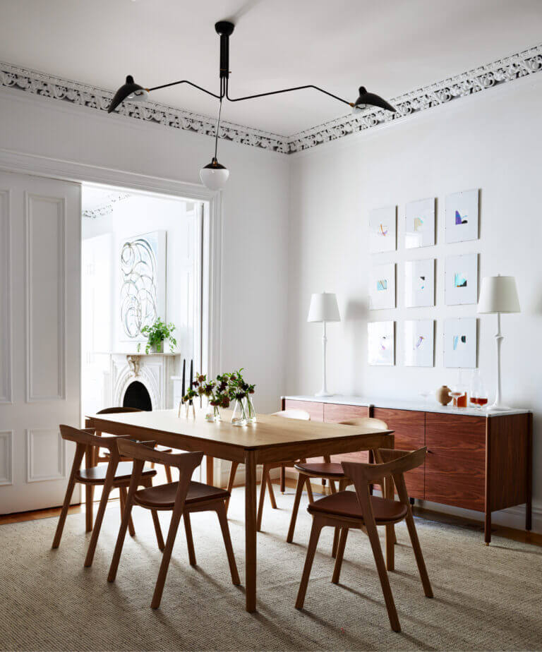 A Brownstone Interior Design dining area featuring a black mid-century light fixture, Bok dining table, and leather-padded Ethnicraft chairs.