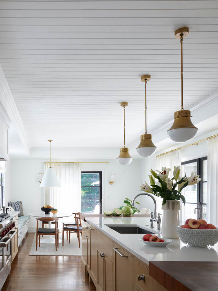 A fully renovated kitchen with natural oak cabinetry, created by removing several small rooms to form a spacious and modern gathering space.