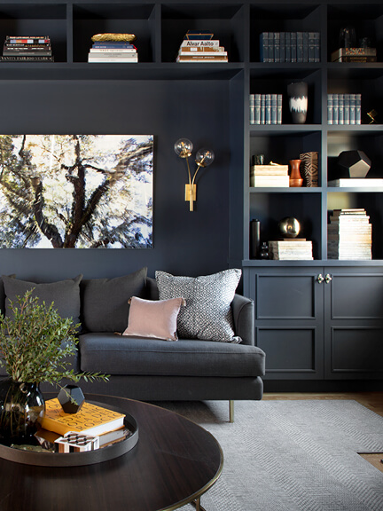 A formal living room painted Benjamin Moore Hale Navy, featuring a basic sofa and coffee table, designed for a full home furnishing guide.