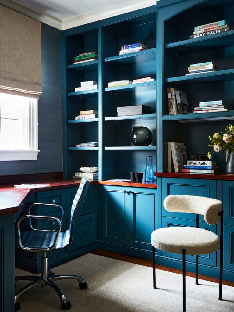 Historic Home Interior Design featuring navy blue office cabinets with matching grasscloth wallpaper, a natural wood countertop, and a boucle side chair in ivory with metal legs.