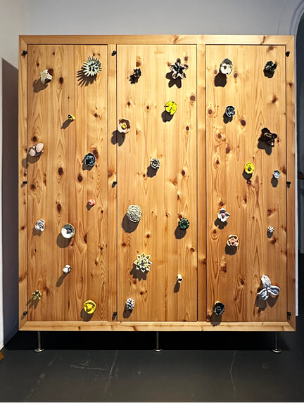 BDDW cabinet made from domestic hardwood with sculpted floral ceramic pulls and cast bronze feet in their Los Angeles showroom