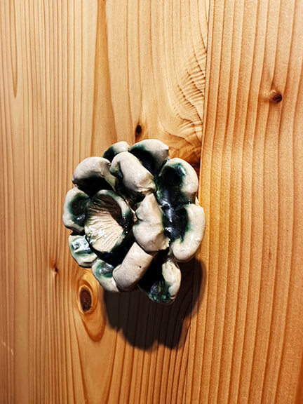 Close-up of floral ceramic pulls on natural domestic hardwood furniture from BDDW’s Rosevale collection