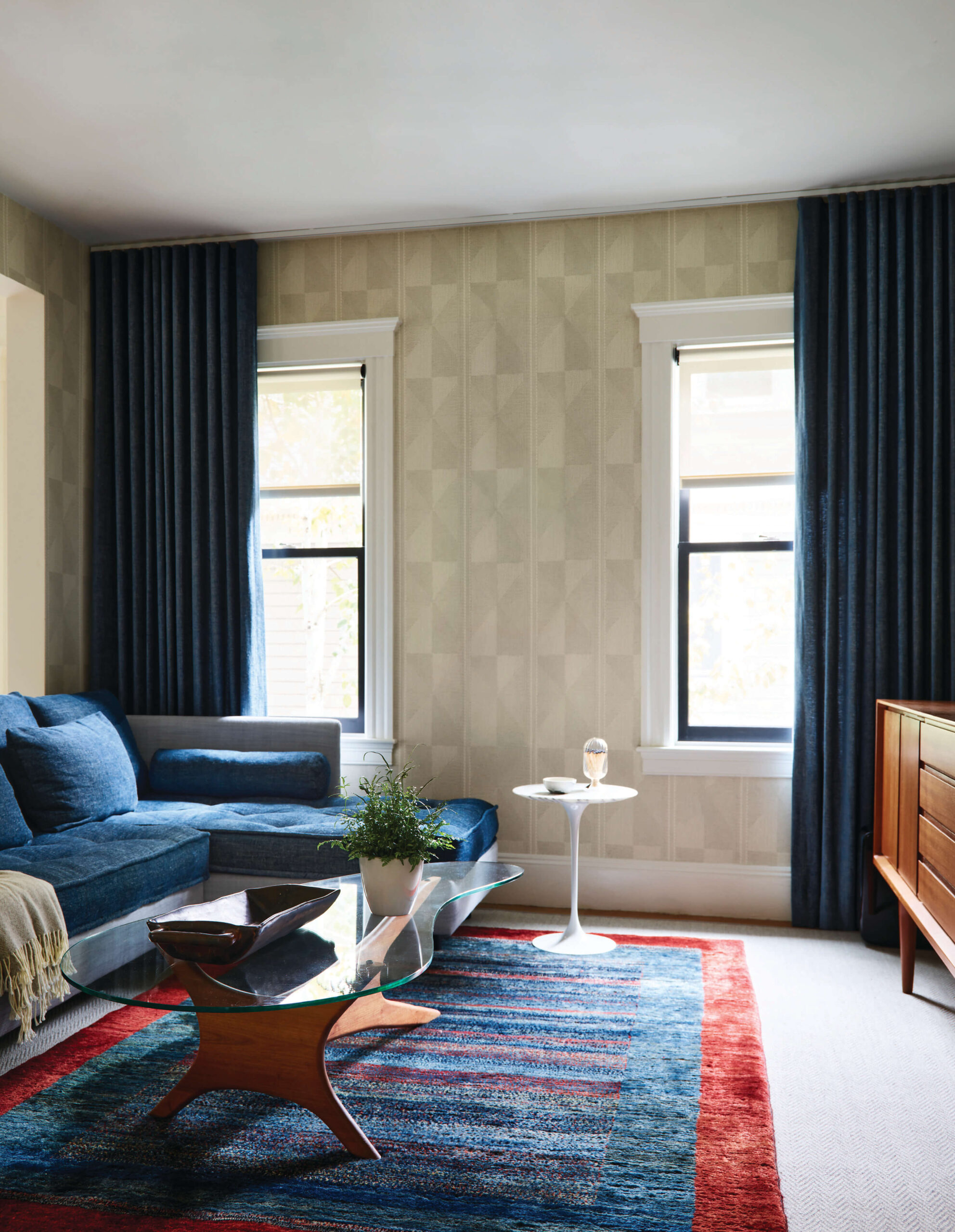 Open floor plan problems avoided with layered wallpaper, modern furniture, and defined space in a Brookline family room.