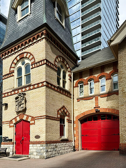 Yellow brick and red door at a historic Toronto fire station with preserved details and active community use.