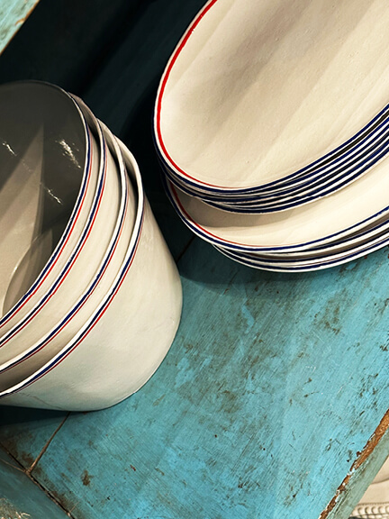 Astier de Villatte French ceramics displayed on aqua vintage shelves at Nickey Kehoe’s Los Angeles showroom