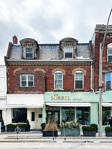 Renovated storefront for Sorrel in Toronto’s Rosedale historic district with a pale green facade and original architectural details