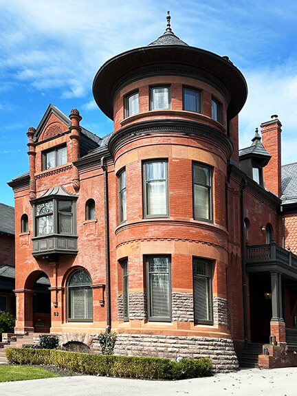 Historic home in Toronto’s Annex with circular turret, asymmetrical architecture, bay window, and detailed brickwork typical of late Victorian design
