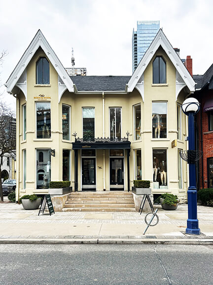Semi-detached Victorian building in Toronto's Hazelton Avenue with symmetrical facade, steep rooflines, and off-white exterior with crisp white trim