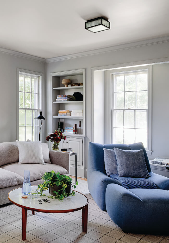 Open floor plan problems addressed in this Hingham family room with traditional windows, trim, and updated modern furnishings.
