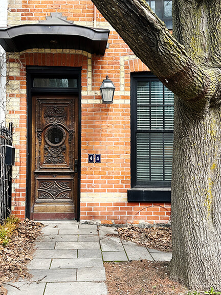 Historic-homes-in-toronto captured in an old entry door with a circular window and ornate architectural detailing.