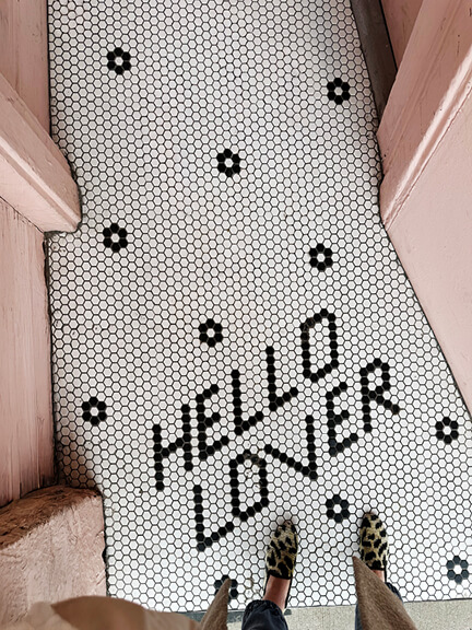 Custom hex tile at Urban Island in Rosedale with floral pattern and the phrase "hello lover" set into the restaurant entry floor.