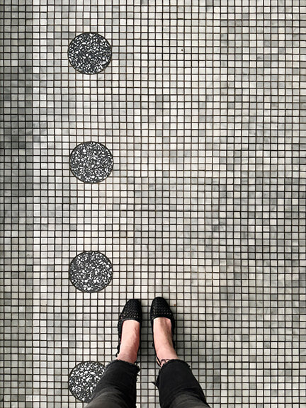 Mosaic terrazzo floor with geometric patterns in a Toronto restaurant, combining historic detail with playful modern design.