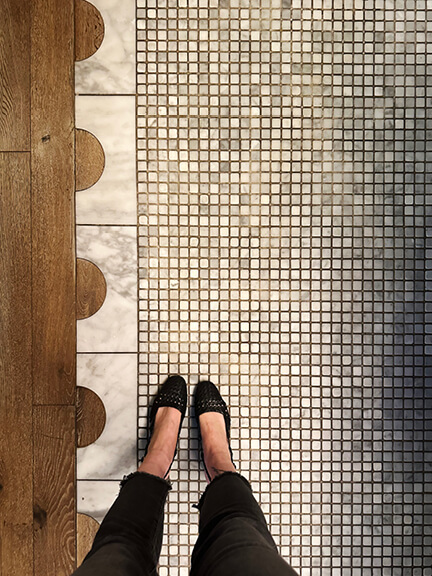 Interior-designer captures wood, marble, and mosaic flooring with semicircle patterns at a Toronto restaurant.