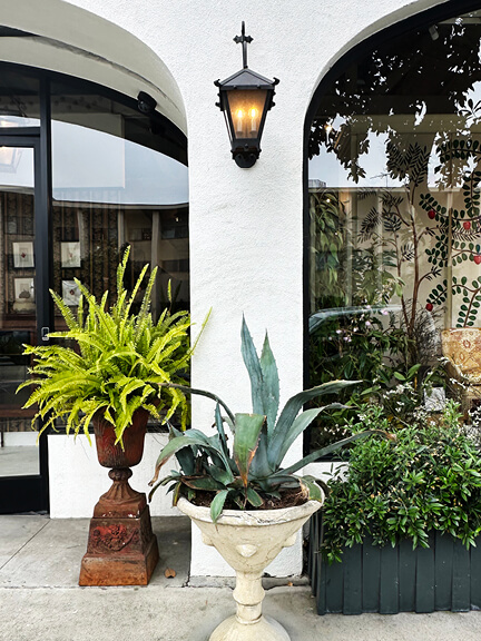 LA interior design showrooms showcase Nickey Kehoe’s studio entry with planters on pedestals and black iron lanterns