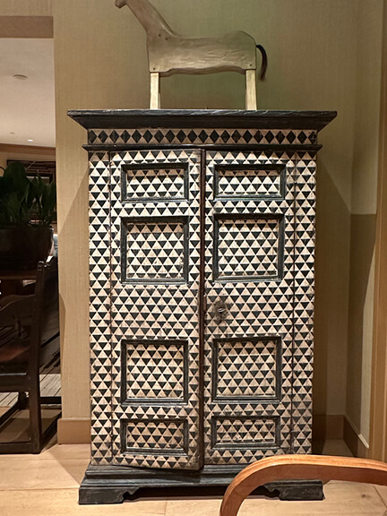 Rose Tarlow armoire with graphic blue and white triangular pattern and reproduction antique furniture in her LA showroom