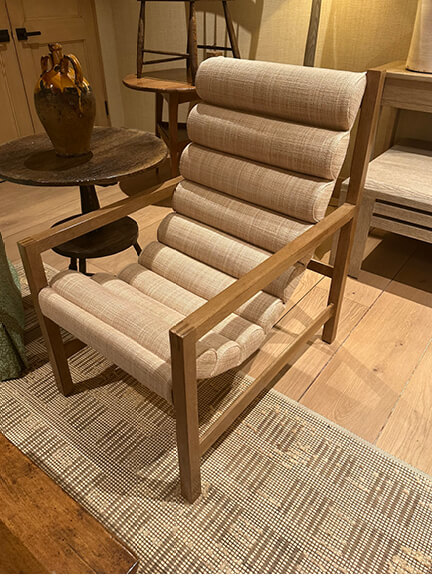 LA interior design showrooms highlight Rose Tarlow's curved lounge chair in light wood and pale linen upholstery