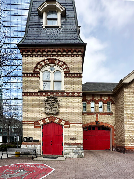 Yellow brick and red door at Toronto firehouse, the city’s oldest functioning station with original architectural detailing.