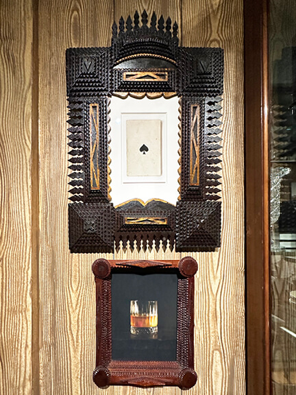 Vintage tramp art frame on faux wood walls at Ken Fulk's LA showroom