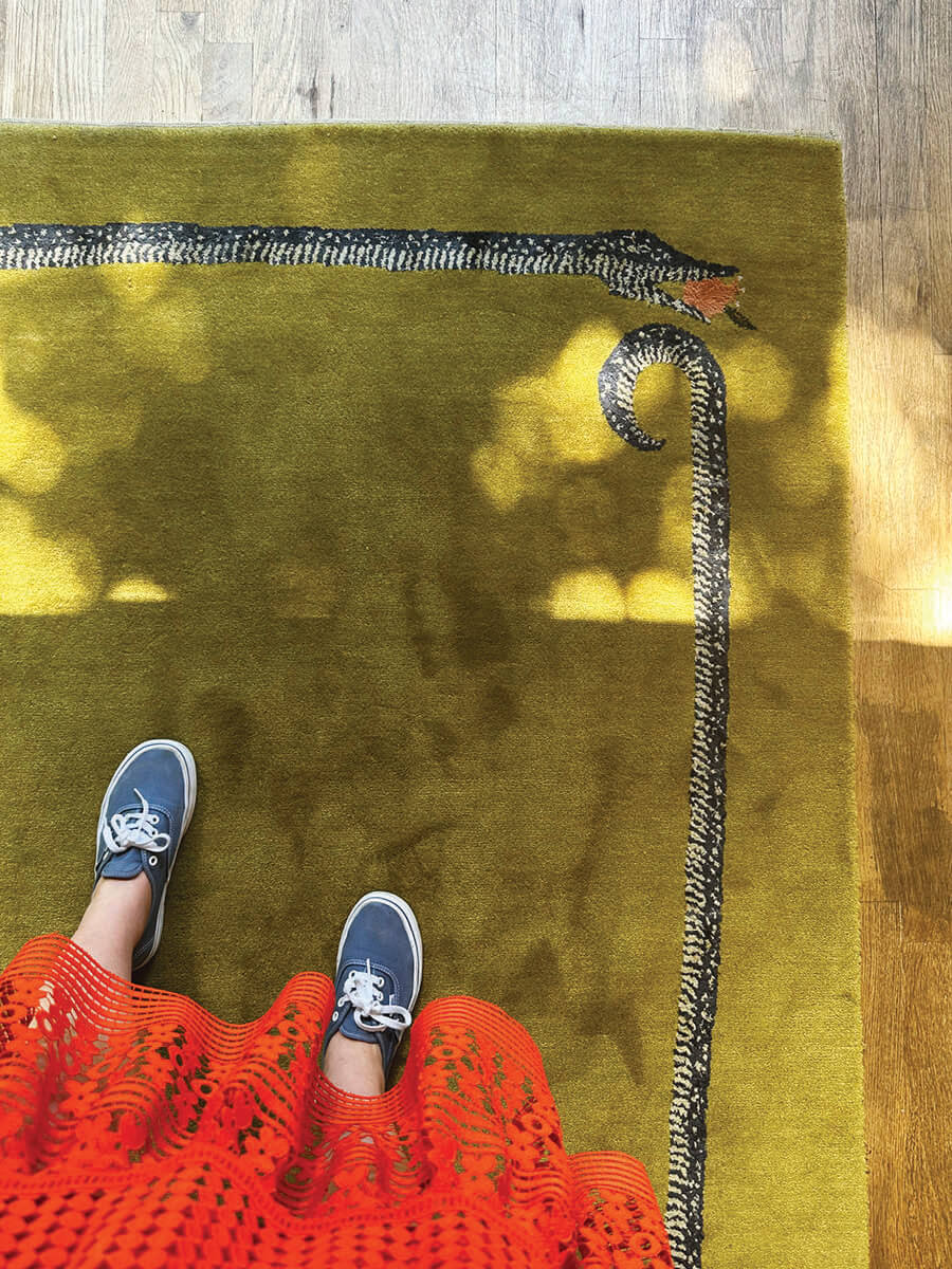 Chartreuse area rug with snake-motif by Christopher Farr displayed in LA showroom, bold pattern and texture