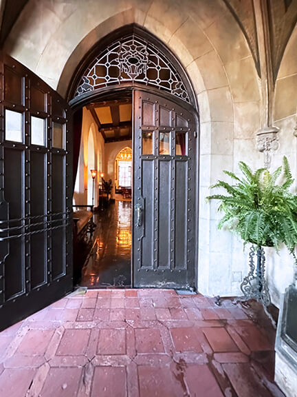 Gothic doors and terracotta tile flooring at the Chateau Marmont restaurant entry, combining historic architecture with warm materials.
