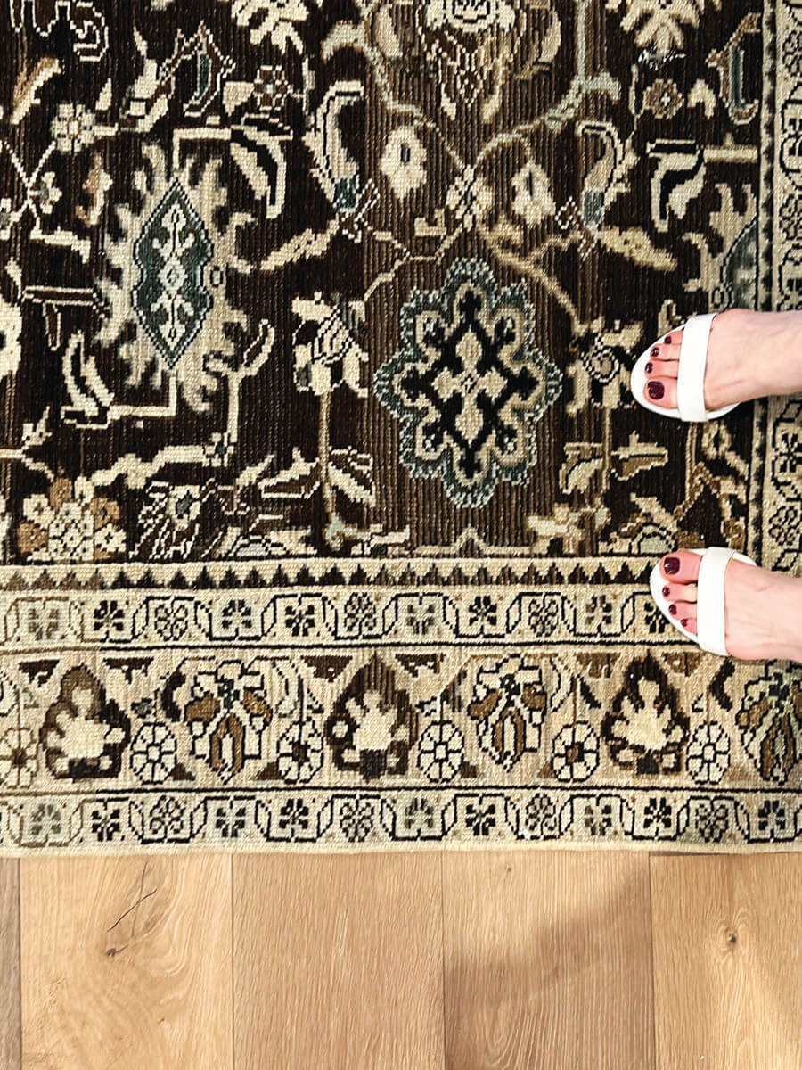 Dark brown vintage area rug at Ben Soleimani showroom in LA, rich texture and classic appeal