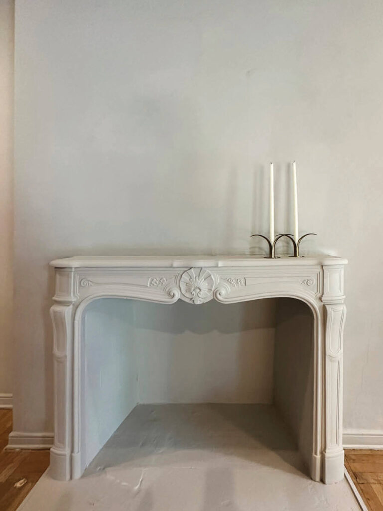 French carved fireplace in light grey with matching walls in LA interior design showrooms at Christopher Farr