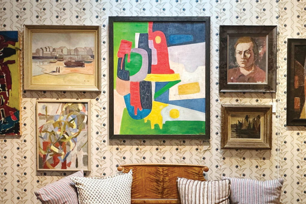Art gallery wall with modern and vintage art on floral wallpaper in LA interior design showrooms at Harbinger
