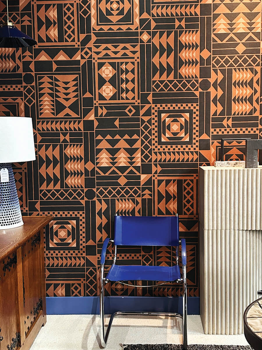 Bold black and orange geometric wallpaper with bold blue chair in LA interior design showrooms at Harbinger.
