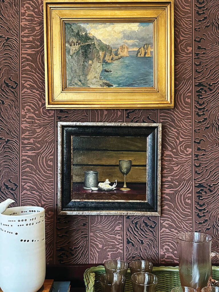 Burgundy print wallpaper with gilded vintage art in LA interior design showrooms at Harbinger.