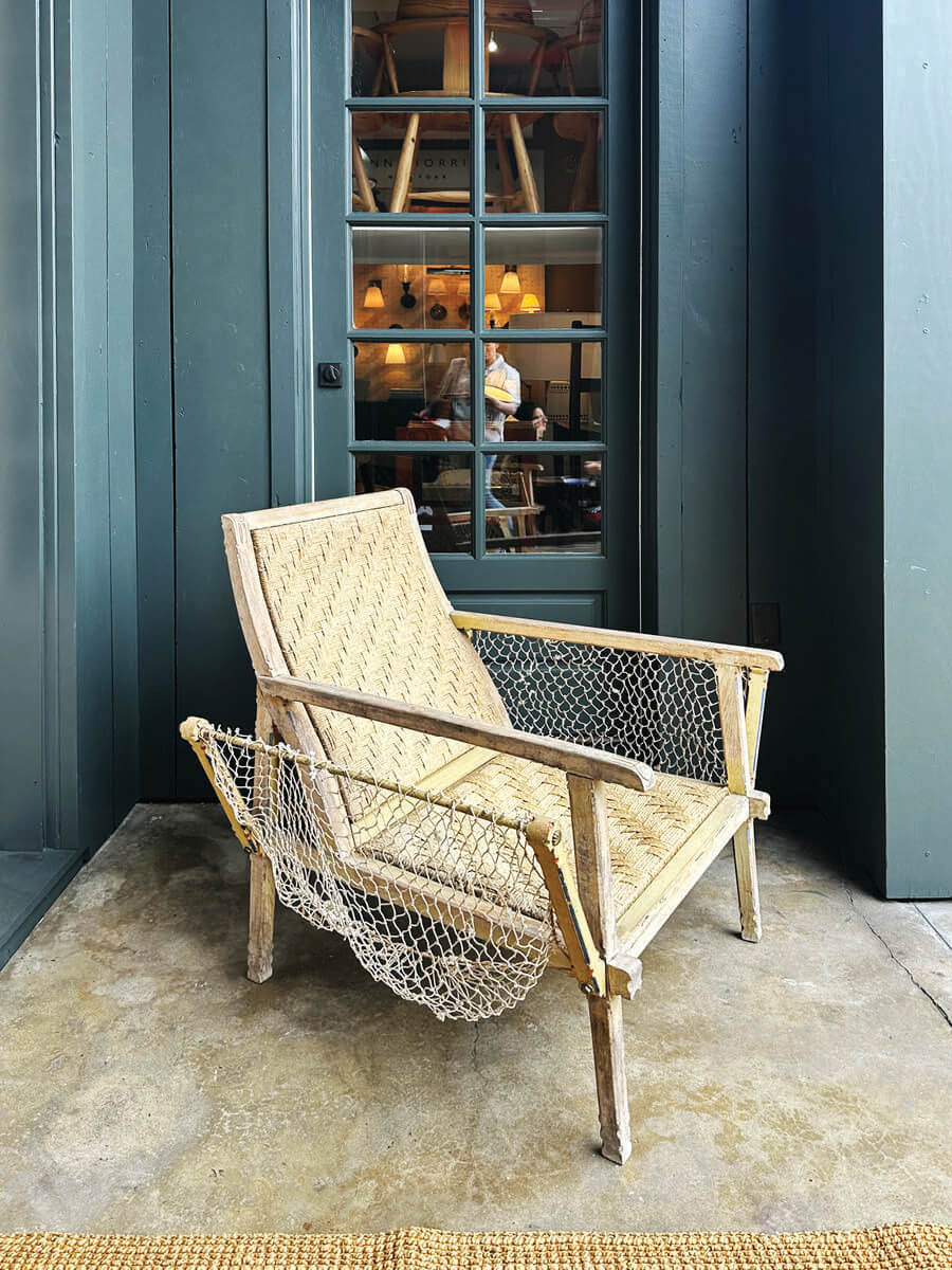 Dark blue entry with vintage Bord de Mer chairs in LA interior design showrooms at Harbinger.