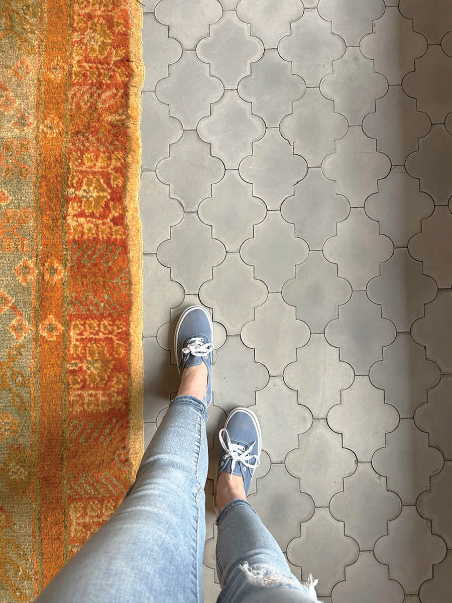 Moroccan tile floor with bold orange rug in LA interior design showrooms at Harbinger.