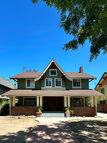 Historic home on Van Buren Place in Koreatown, Los Angeles, featuring early 20th-century architecture with neutral paint and porch details.