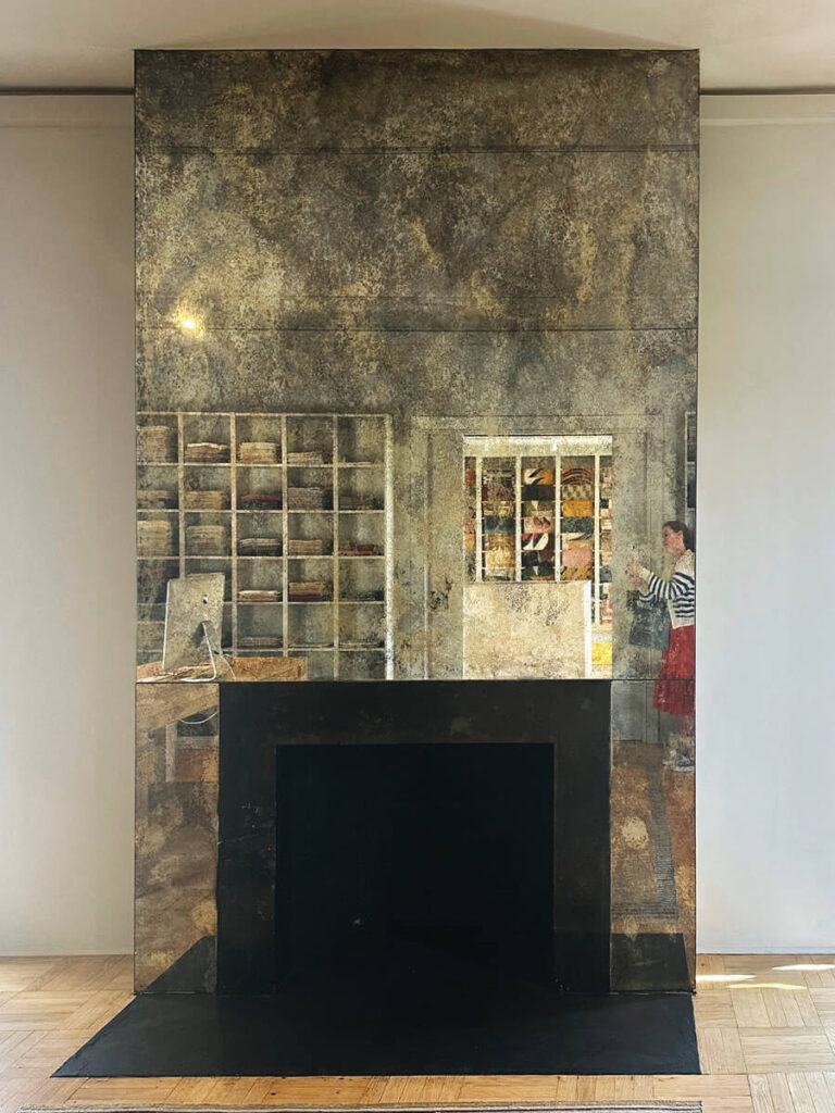Mirrored modern fireplace in LA interior design showrooms with sleek reflective surfaces.