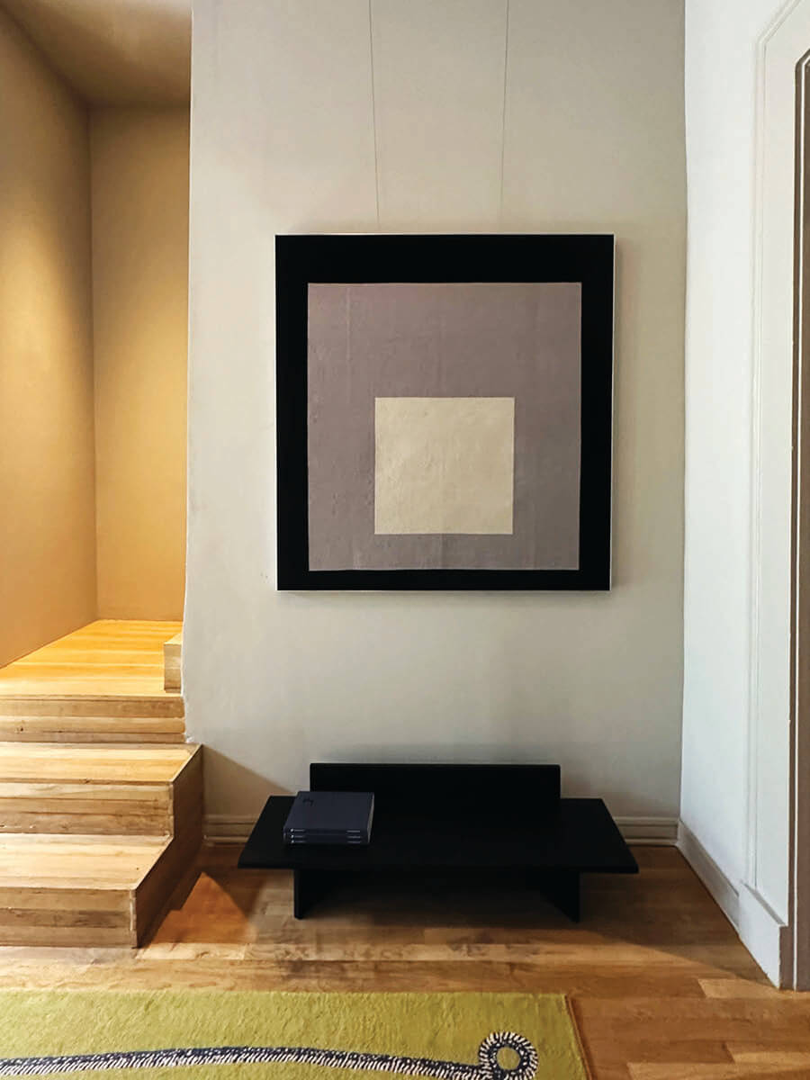 Modern showroom design with parquet floors, light grey walls, and concentric geometric art at Christopher Farr LA.