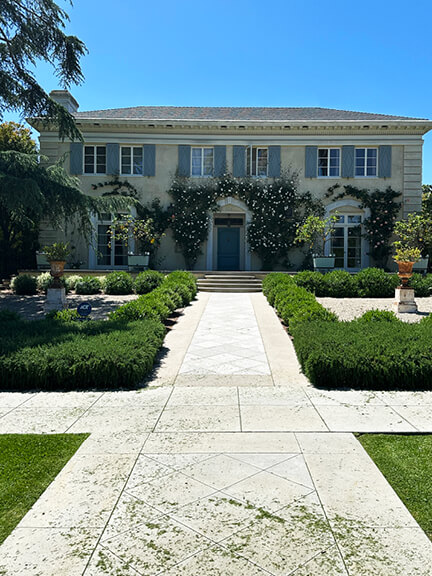 Historic architecture in Los Angeles featuring a stucco facade, light blue shutters, and matching doors on a classic early 20th-century home.