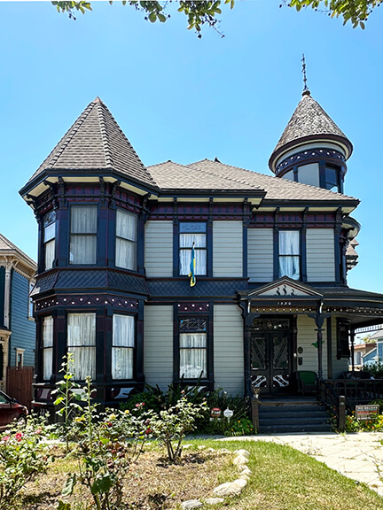 A maroon, blue, and off-white Victorian home on Carroll Avenue in Angelino Heights, part of historic architecture in Los Angeles.