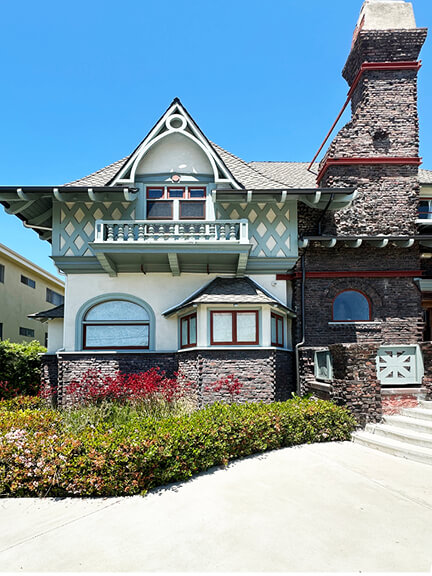 Historic architecture in Los Angeles shown in the Fitzgerald House—a brick Colonial Revival home with pale green trim in West Adams.